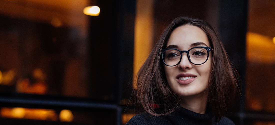 Young Woman In Black Sweater And Glasses